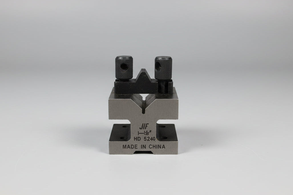 Metal tool or device on a wooden surface with a plain background