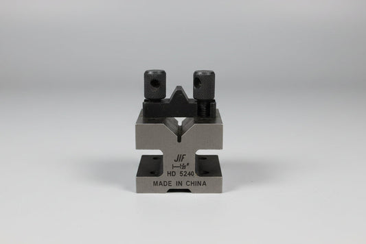 Metal tool or device on a wooden surface with a plain background
